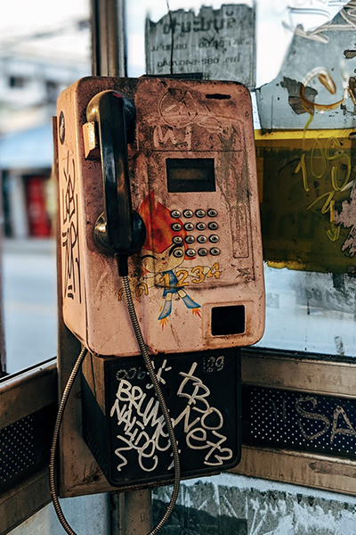 a view inside an old dirty phone booth with graffiti