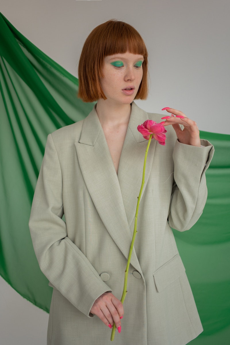 a young woman holding a pink flower