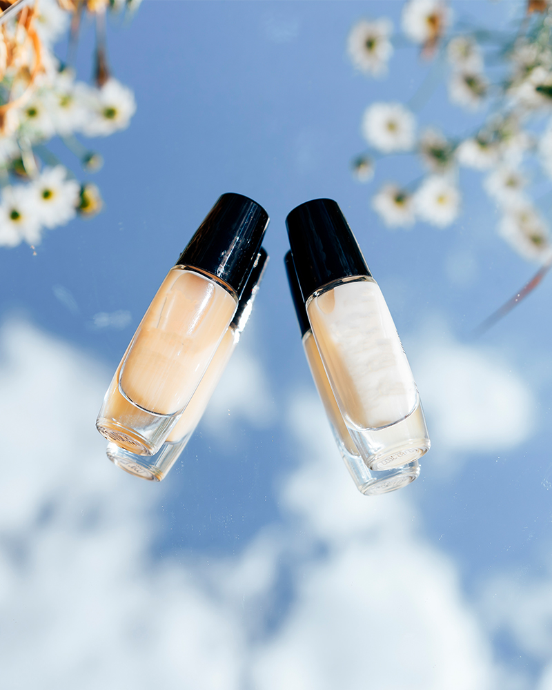 Aesthetic photo of cosmetics products on a surreal sky and cloud background