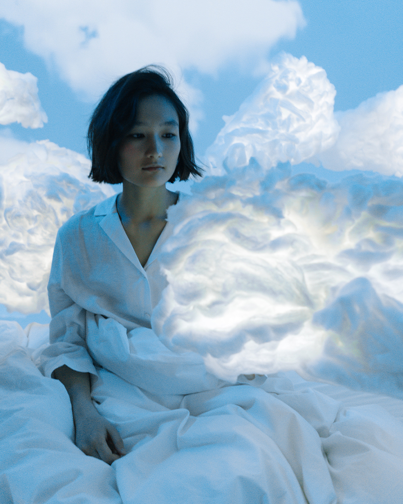 Aesthetic image of young Asian woman young on a surreal sky and cloud background