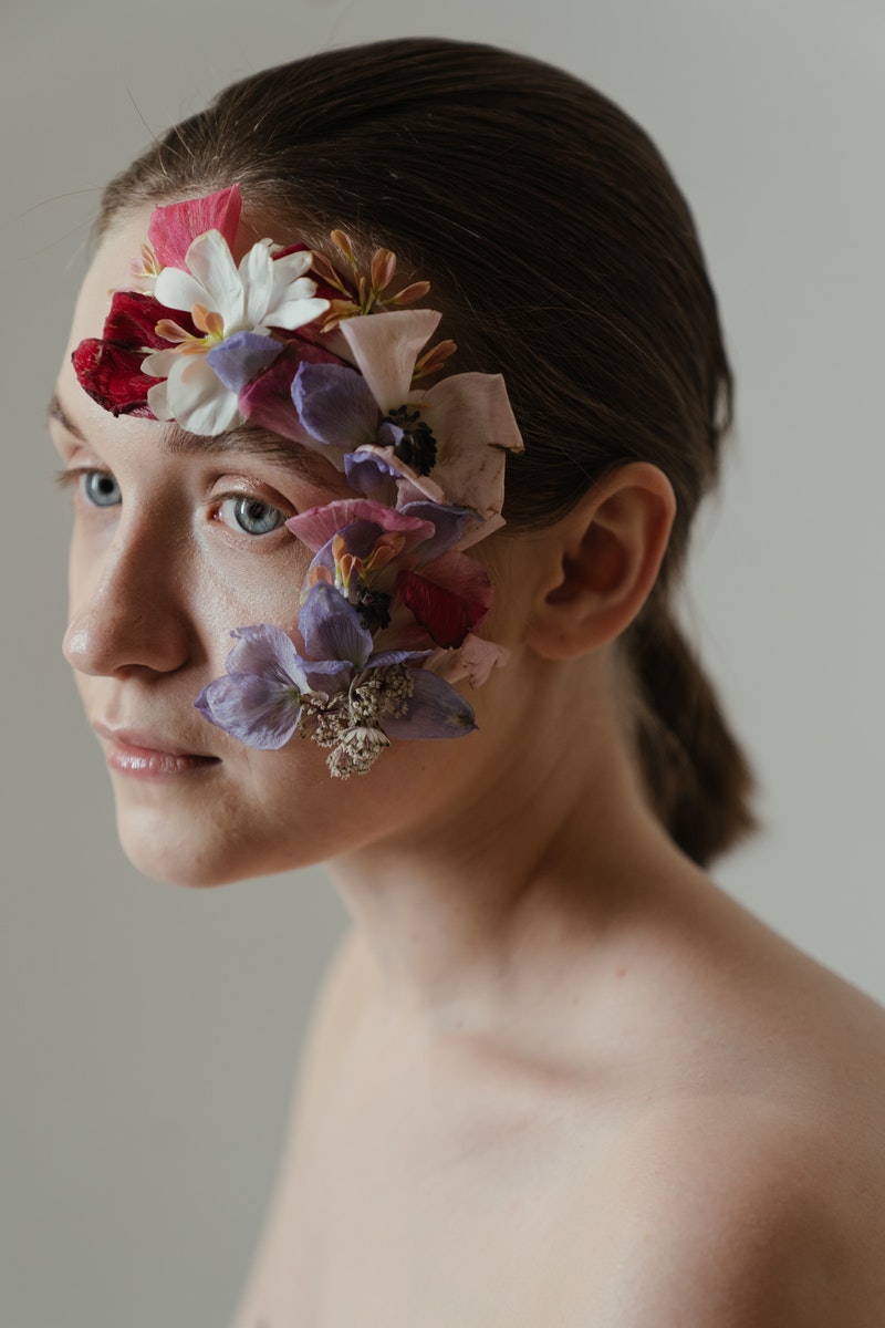 a young woman with flowers on her face