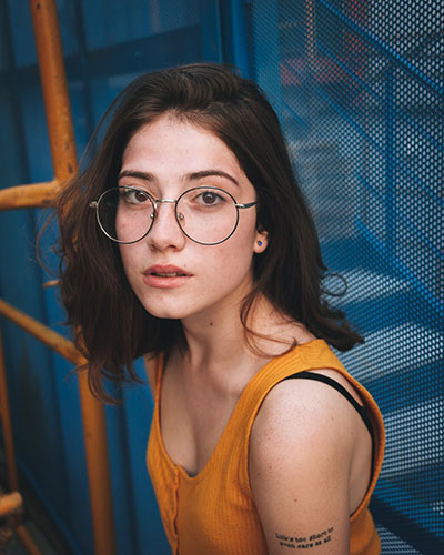 a girl with glasses in the center of a picture with non-distracting background is a good example of subject photography